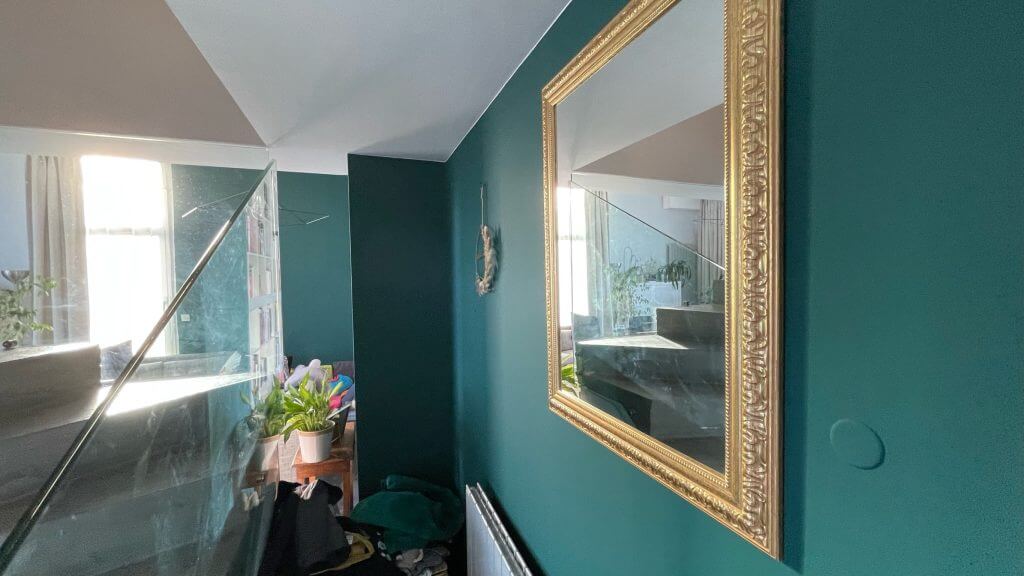 Mur vert foncé et miroir doré